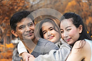 Asian family, father, mother and daugther having goodtime together in park in autumn season photo