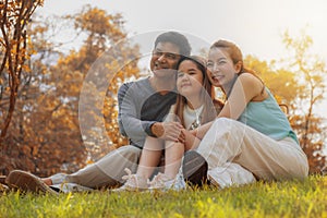 Asian family, father, mother and daugther having goodtime together in park in autumn season photo