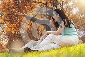 Asian family, father, mother and daugther having goodtime together in park in autumn season photo