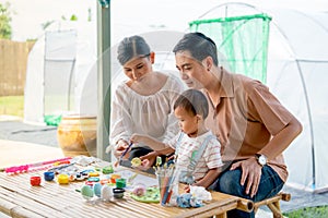Asian family with father mother and son enjoy to have good activity together to paint eggs relate to easter festival with day