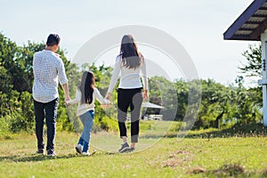 Asian family having fun and enjoying outdoor walking down the road outside together in the park