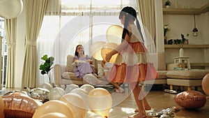 Asian family having fun playing balloons at home, family relationship concept