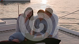 An Asian family is having a good time. Spending time on a yacht at sunset is a wonderful way to unwind