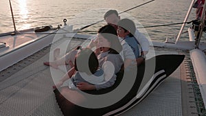 An Asian family is having a good time. Spending time on a yacht at sunset is a wonderful way to unwind