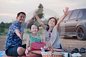 Asian family having a picnic in the park with smile and happy