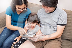 Asian family holding a tablet computer and looking at it