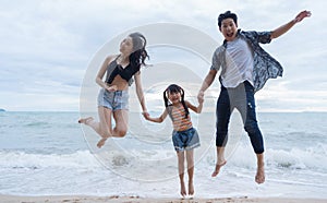 Asian Family jumping together at beach with kids happy vacation travel beach concept.