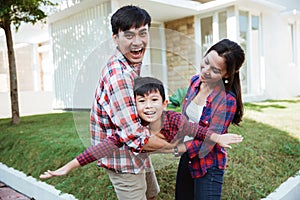 Asian family with kid portrait in front of their house