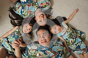 Asian family laying on floor smiling