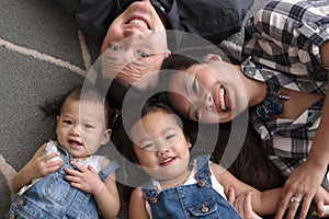 Asian family lying on floor smiling and laughing