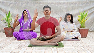 Asian family member doing yoga or meditating while making the Blessing Buddha hand sign