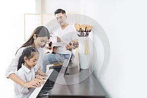 Asian family, mother and daughter playing Piano,father playing