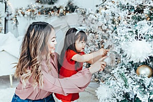 Asian family mother with daughter toddler girl celebrating Christmas or New Year at home