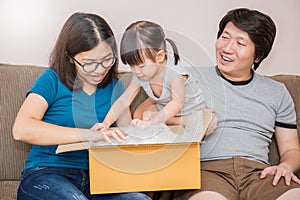 Asian family moving house unpack the box together