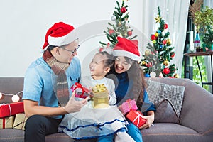 Asian family opening their presents together on Christmas morning.