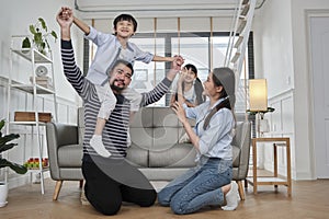 Asian family is playing and teasing together in the living room