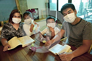 Asian family quarantine at home reading book in home living room