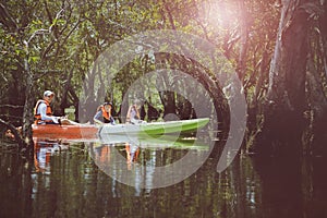 asian family sailing fresh water kayak in mangrove lagoon,kayaking is one of most popular activity in young people lifestyle