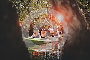 Asian family sailing sea kayak in mangrove forest