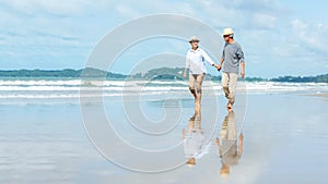 Asian family senior elderly couple running on the beach happy enjoy in love romantic and relax time.  Tourism elderly