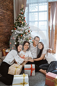 Asian family sitting on the floor with gift box present