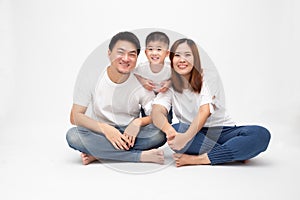 Asian family smiling and sitting together on floor isolated white background.