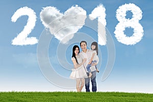 Asian family standing under numbers 2018