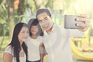 Asian family taking selfie at the park
