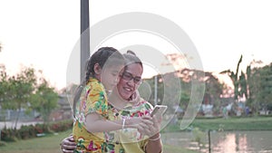 Asian Family Taking Selfie With Smartphone In The Public Park.