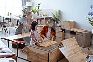 asian family at their new house buying and assembling new furniture.