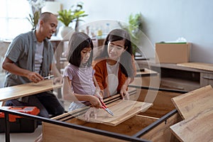 asian family at their new house buying and assembling new furniture.