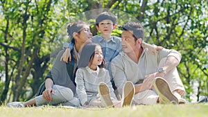 Asian family with two children relaxing outdoors