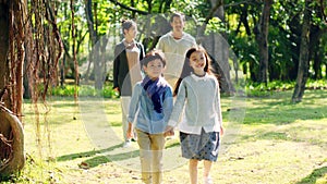 Asian family with two children relaxing in park