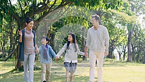 Asian family with two children relaxing in park