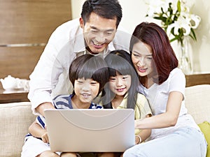 Asian family with two children using laptop together