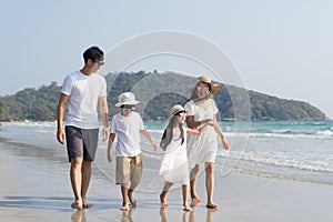 Asian Family walking at beach with kids happy vacation concept.