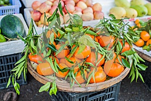 Asian farmer market selling fresh Mandarin in Hoi An, Vietnam. Orange and green colors.