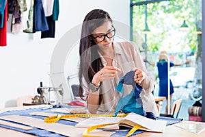 Asian fashion designer woman sewing in her workshop