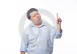 Asian Fat Man in blue shirt thinking and pointing to copy space with doubts face isolated on white background.