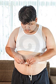 Asian Fat man holding a measuring tape
