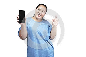 Asian fat overweight woman holding a mobile phone and showing an empty screen