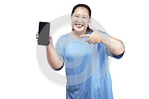 Asian fat overweight woman holding a mobile phone and showing an empty screen