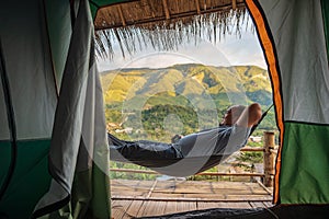 Asian fat traveler sleeping on the hammock  with beautiful mountain view of Sapan Village At nan Thailand.