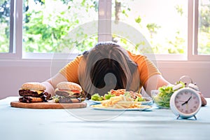 Asian fat woman sitting at the dining table Had hamburgers and fries.