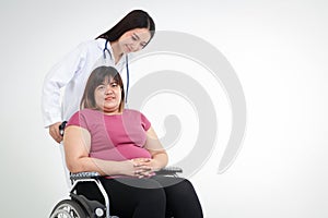 Asian fat woman sitting on a wheelchair Have a female doctor to help take care of inquiring about the illness.