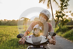 Asian father and child  ride motorcycle scooter