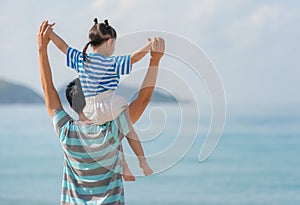 Asian father and daughter on the beach
