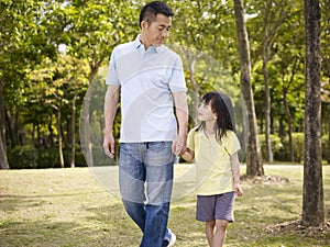 Asian father and daughter takes a walk in park