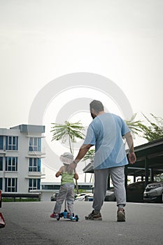 Asian father and daughter walking  and playing on the road at the day time. People having fun outdoors. Concept of friendly family