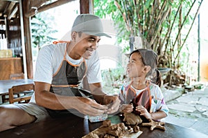 Asian father and daughter working with clay